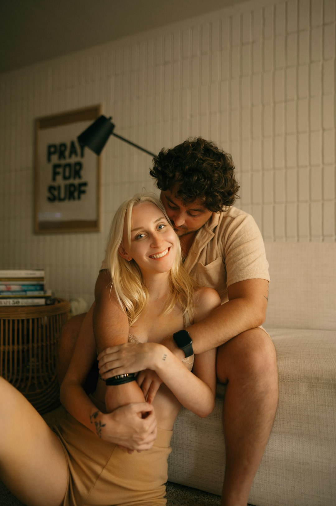 A couple sitting close together on a sofa at home